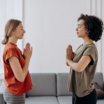 Two women peacefully meditating at home