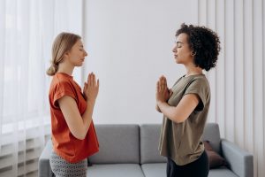 Two women peacefully meditating at home