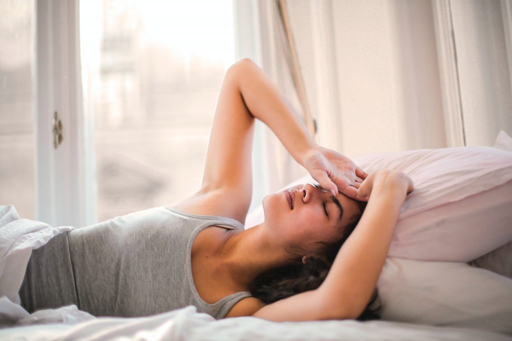 Woman in bed peacefully waking up to follow her self care morning routine