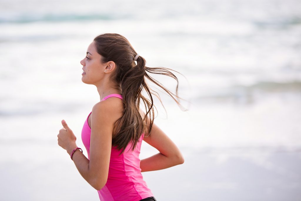 Healthy woman running on the beach for starting your day right