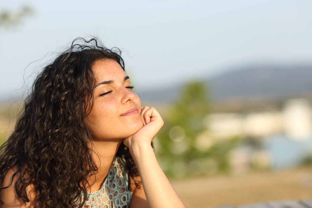 Woman,Relaxing,And,Enjoying,The,Sun,In,A,Warmth,Park, get rid of her emotional triggers, peaceful emotions