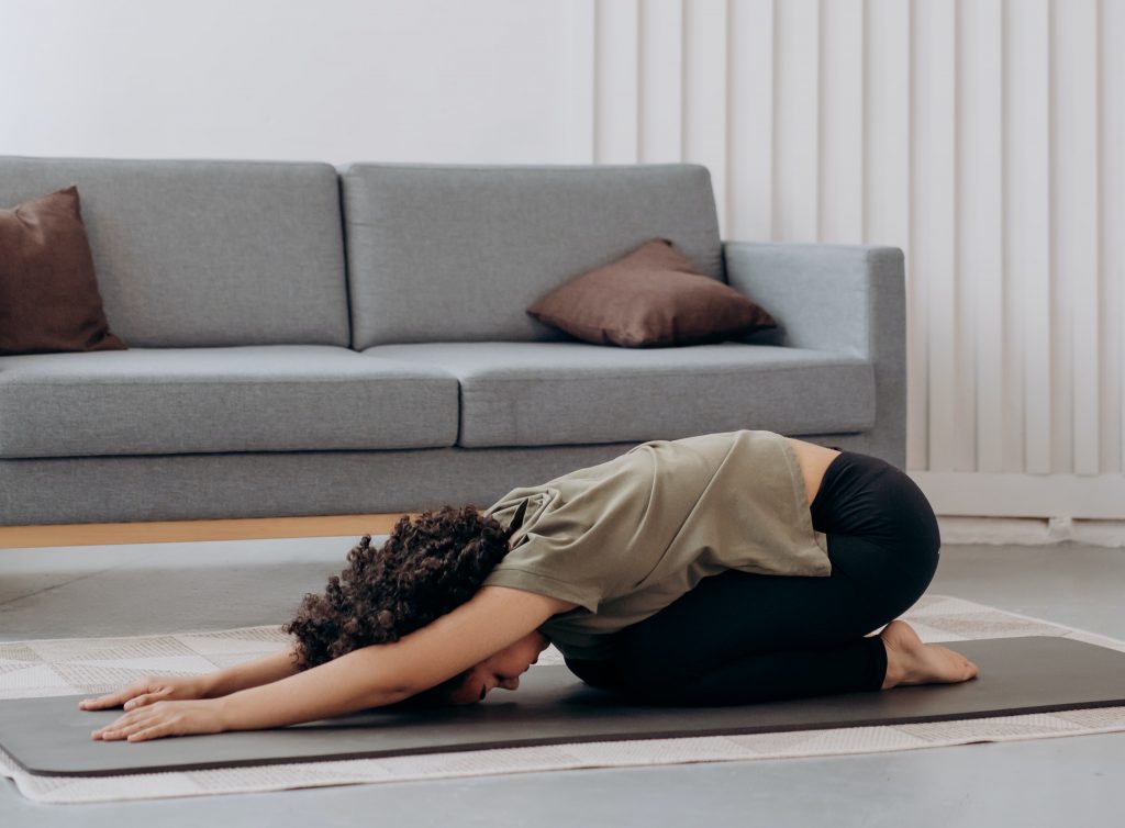 Woman practicing yoga at home to prevent sleepless nights