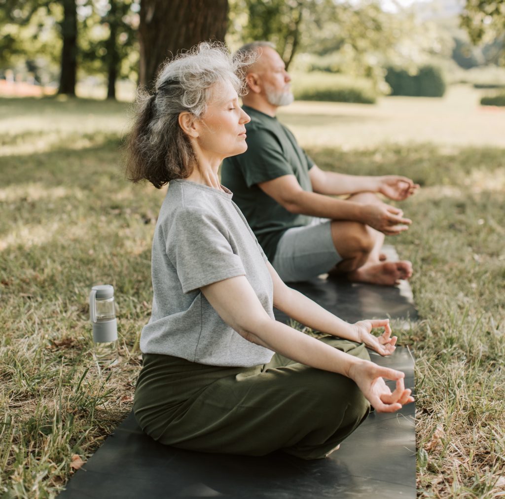 Old couple meditating in nature to prevent sleepless nights