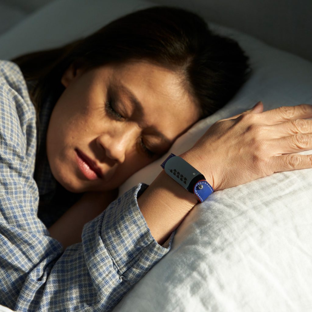 Woman sleeping in her bed and tracking her sleep quality with her GEMA Fitness Tracker