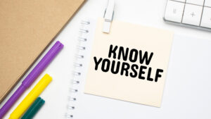 'KNOW YOURSELF ' written on post-it note attached to a Notebook