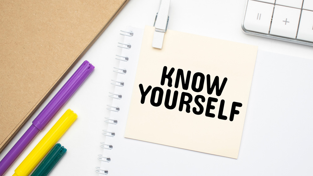 'KNOW YOURSELF ' written on post-it note attached to a Notebook