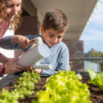 two people watering plants