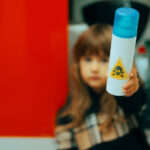 Kid holding a can with a poison sign on it