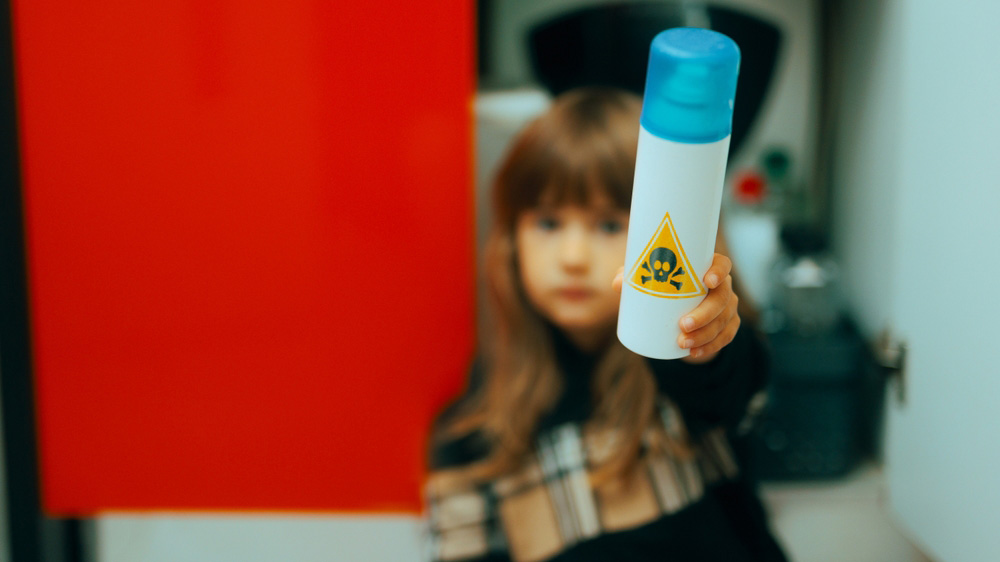 Kid holding a can with a poison sign on it