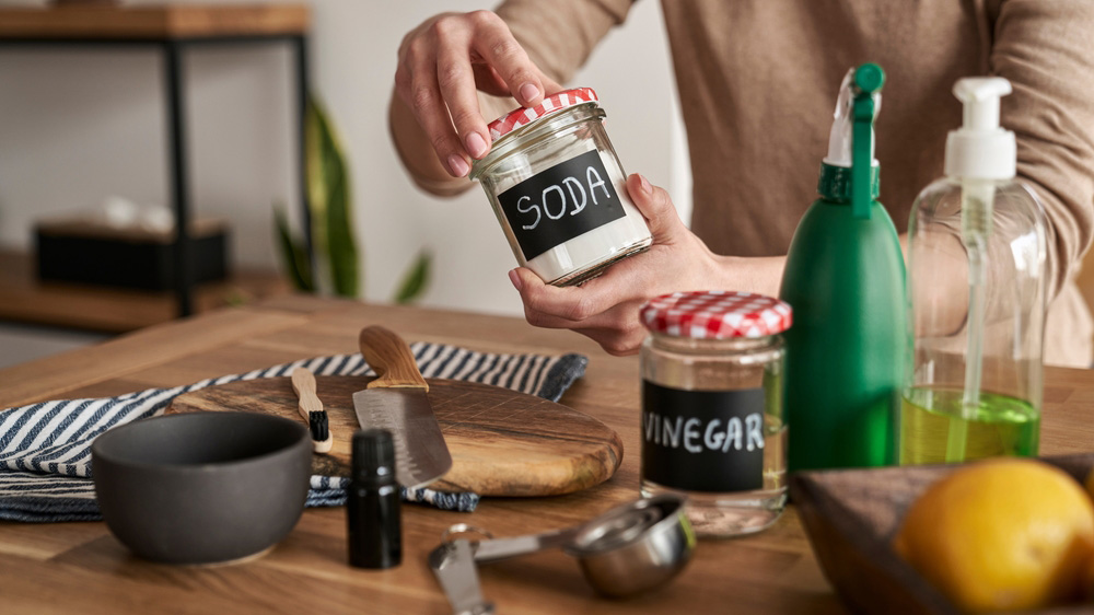Unrecognizable person making cleaning product from ecological ingredients