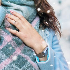 Zoom on a hand wearing a GEMA fitness tracker under the snow
